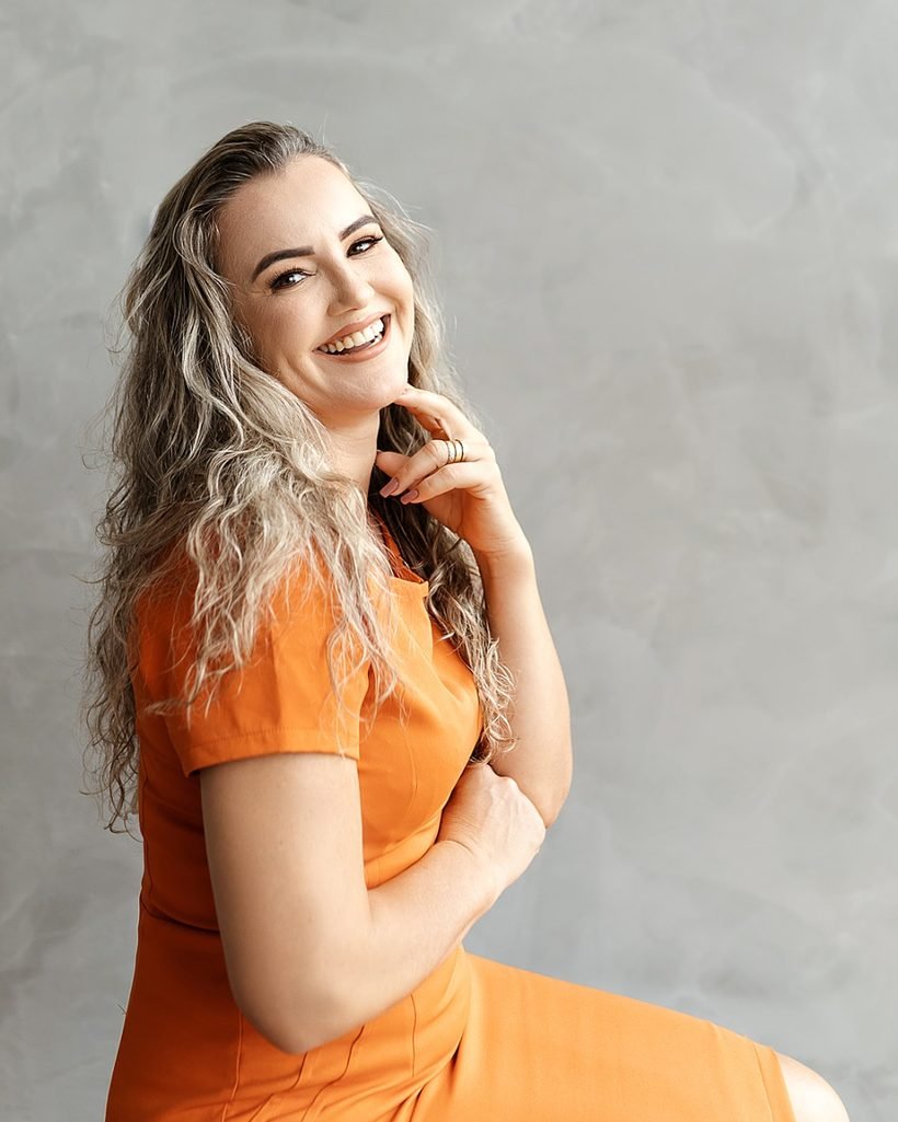 Jaci Silva, da Pura Essenza Clinic, sorrindo, com os cabelos longos e soltos